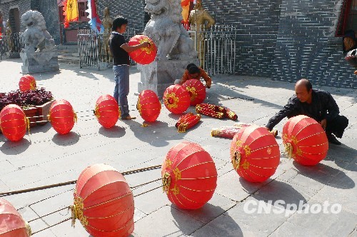 8月31日，河南省開封市天波楊府門口，工作人員在準(zhǔn)備懸掛大紅燈籠。隨著“十一”國慶節(jié)和“十一”旅游黃金周的臨近，古城開封的公園景點已早早開始備戰(zhàn)，營造喜慶祥和的旅游環(huán)境，迎接八方客人。 中新社發(fā) 李俊生 攝