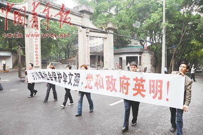 5月21日，文強被宣判死刑后，重慶群眾自發來到重慶市委門前，打出條幅：“打掉黑社會保護傘文強，黨和政府英明！” 本報記者 田文生攝