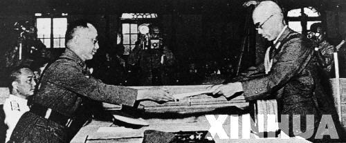 日本中國派遣軍總司令官岡村寧次在對華投降書上簽字，并向中方交出他的隨身佩刀，以表示侵華日軍正式向中國繳械投降。這是何應欽(左)在南京代表中國政府接受侵華日軍總司令岡村寧次的投降書。新華社發