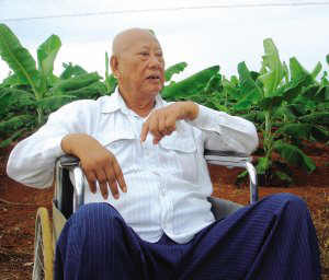 陳光保在自己的農(nóng)場(chǎng)里，他身后就是一片香蕉林(中青報(bào)蔣昕捷供圖)