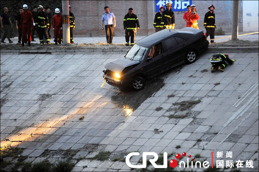2012年6月17日下午，北京四元橋下方的西壩河輔路上，一輛轎車失控墜河中。消防員將轎車拖上岸。