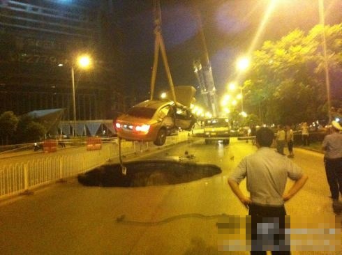 吊車將墜入塌陷坑的汽車吊出。圖/末代小王爺