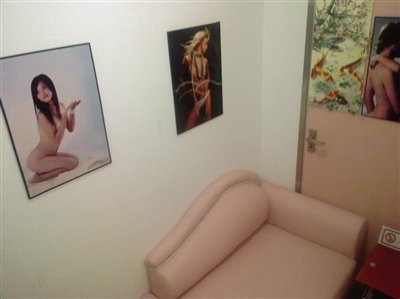 取精室內，有一個粉色沙發，墻壁四周掛著女體畫
