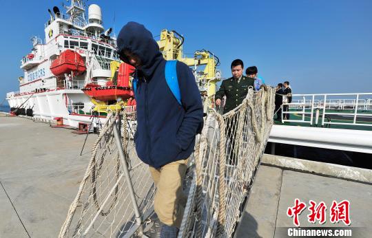 圖為24名“驢友”的“導游”被邊防的工作人員帶下船接受調查。 駱云飛 攝
