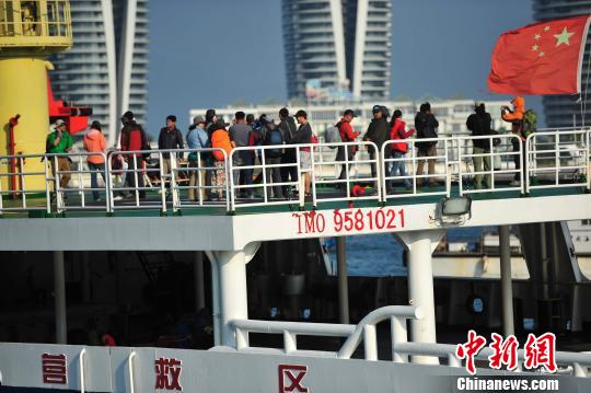 圖為24名“驢友”的“導游”被邊防的工作人員帶下船接受調查。 駱云飛 攝