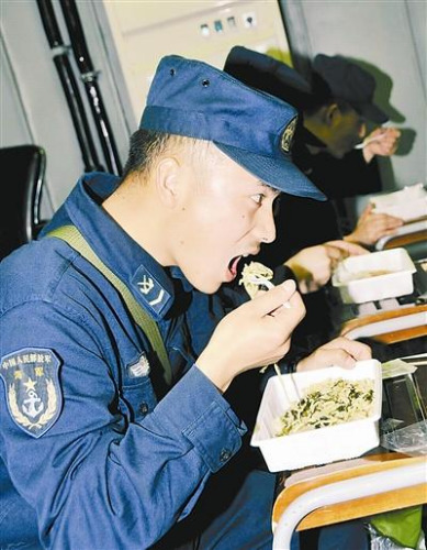 “青島”艦上的官兵在戰(zhàn)位上吃野戰(zhàn)快餐。解放軍報 記者 米晉國攝
